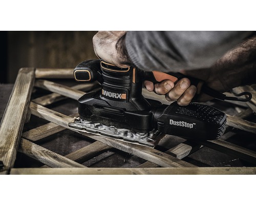 Person slipar trä med en WORX planslipmaskin med dammutsug