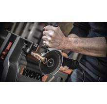 Man skär kopparrör med en vinkelslip i en arbetsbänk från Worx