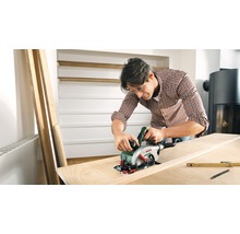Man sågar träplanka med handhållen cirkelsåg, Bosch logotyp