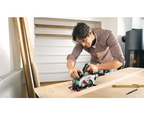 Man sågar träplanka med handhållen cirkelsåg, Bosch logotyp