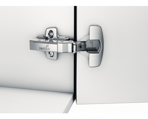 Möbelskåpsgångjärn på en vit skåpdörr med Hettich-logotyp