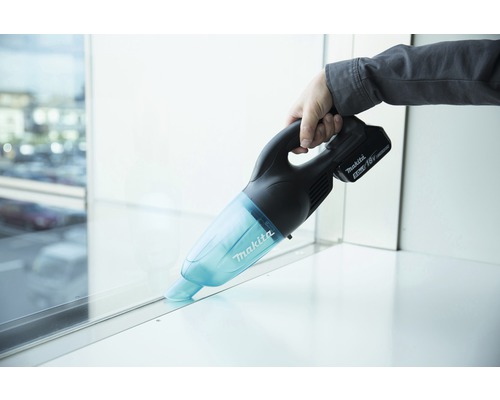 Makita batteridriven handdammsugare som används på fönsterbrädan