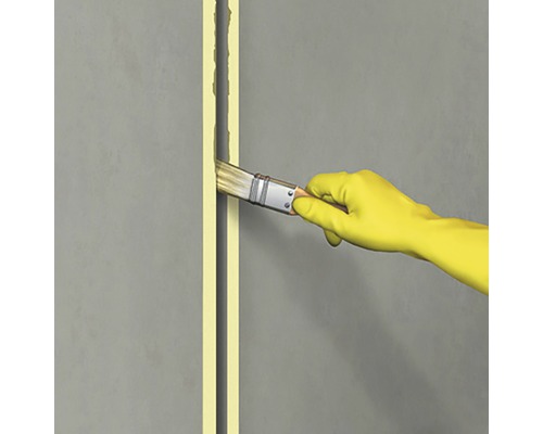 Person med handskar applicerar fogmassa med pensel