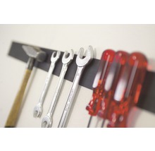 Hammare, skiftnycklar och skruvmejslar på magnetisk verktygsremsa