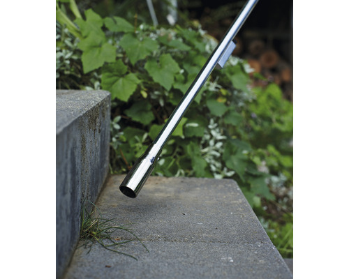 Detaljbild av ett räcke i rostfritt stål på en betongtrappa utomhus.