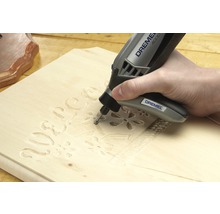Dremel multifunktionsverktyg som graverar en träbit.