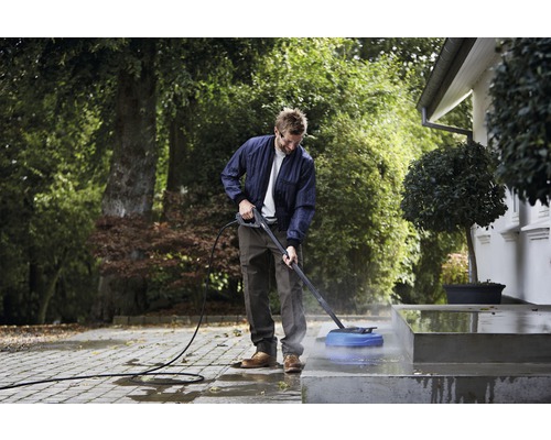 Man rengör en utomhustrappa med en högtryckstvätt.