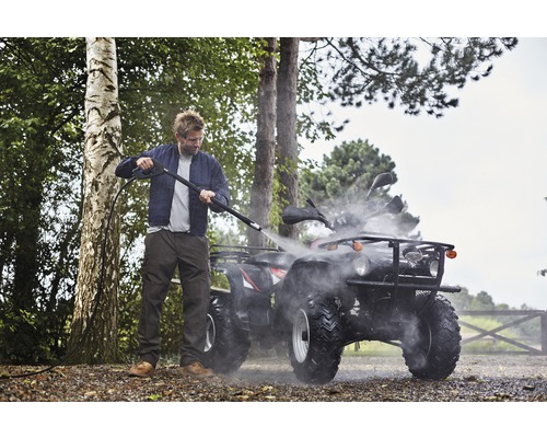 Man rengör fyrhjuling med högtryckstvätt utomhus