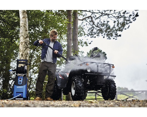 Man rengör fyrhjuling med högtryckstvätt utomhus.