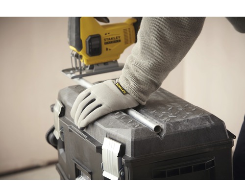 En sticksåg skär ett rör på en verktygslåda