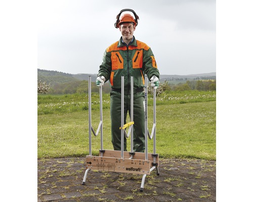 En man i skyddskläder står bakom en vedstapel från Wolfcraft som står utomhus.