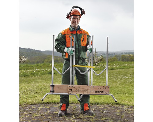 Man med skyddskläder och Wolfcraft vedkapbock utomhus