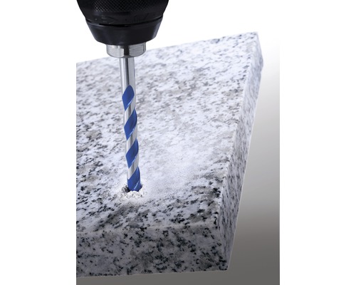 En borrmaskin borrar ett hål i en stenplatta med en stenborr.