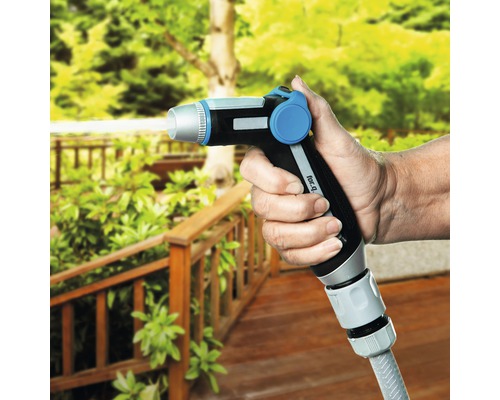 Hand håller trädgårdsslangsprutpistol utomhus.