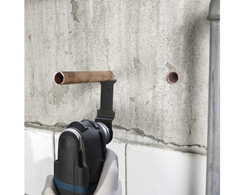 Multifunktionsverktyg skär kopparrör på en vägg