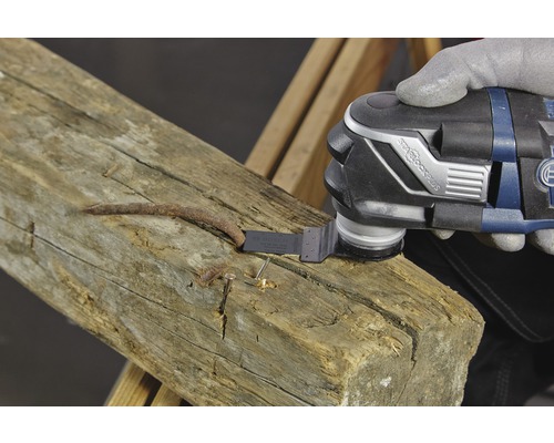 Multifunktionsverktyg som används för att ta bort en spik från en träbjälke