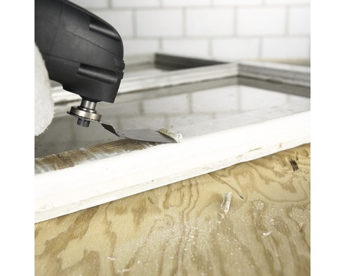 Oscillerande elverktyg som tar bort färg från en fönsterkarm