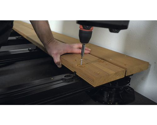 Trädgårdsdäckskonstruktion: Skruv skruvas i träplanka