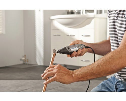 Man skär kopparrör med ett Dremel multifunktionsverktyg