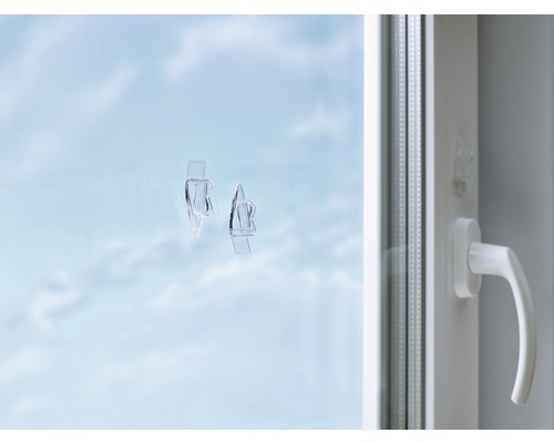 Fönster med transparenta självhäftande krokar för fastsättning av fönsterdekorationer