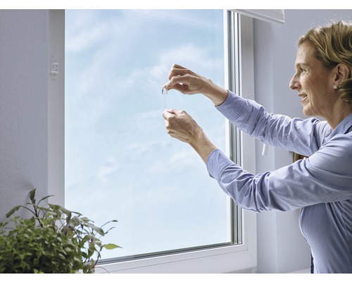 Kvinna mäter fukt på fönstret med en testremsa