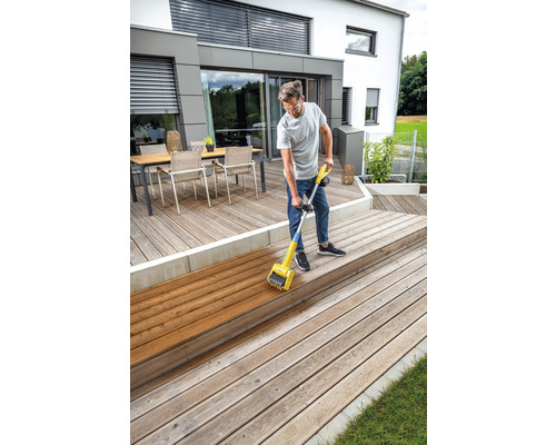 Man behandlar trädäck med en träoljeanordning