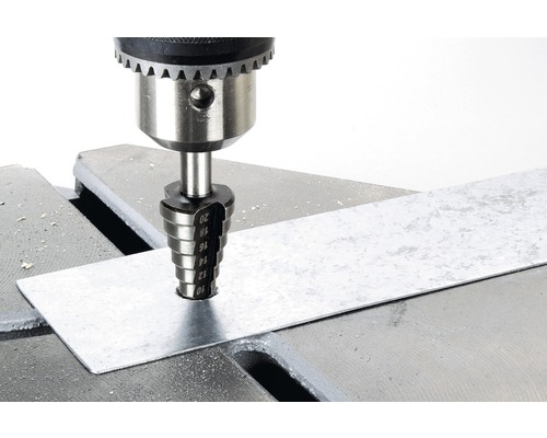Stegborr borrar ett hål i en metallbit