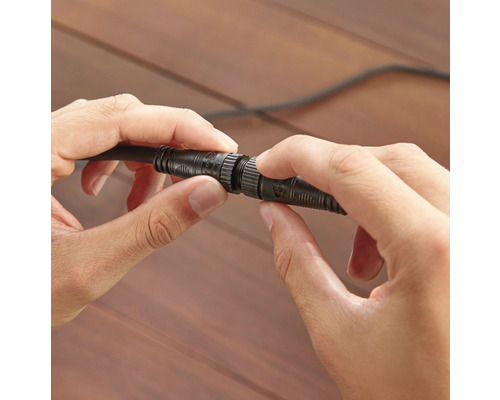 Två händer kopplar ihop en kabel