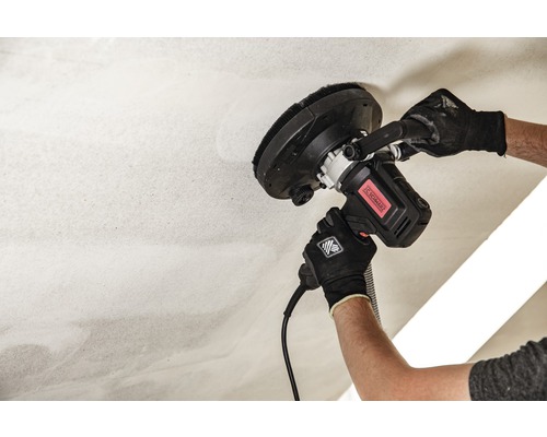 En man slipar ett tak med en takslipmaskin.