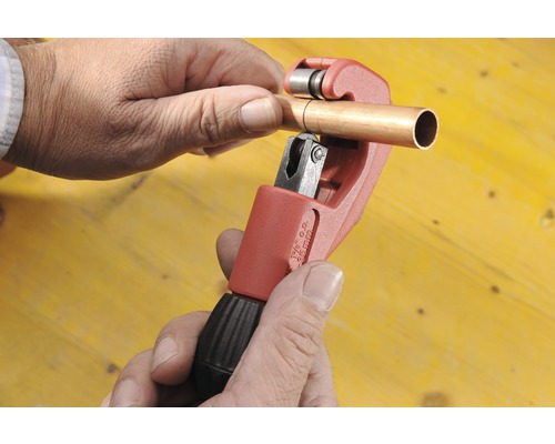 Ett kopparrör bearbetas med en rörskärare.