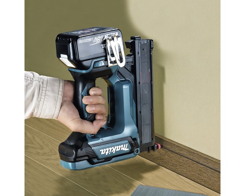 Batteridriven spikpistol som används på en golvlist