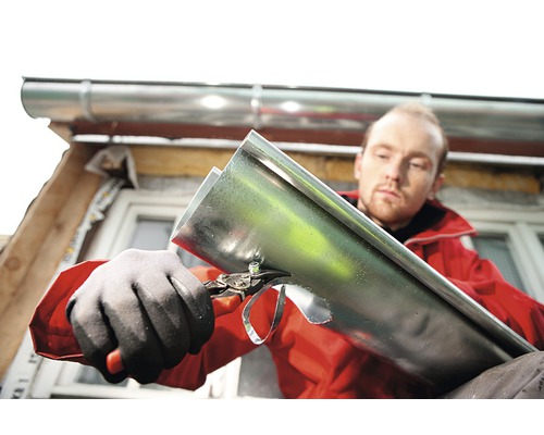 Man skär rännan med plåtsax