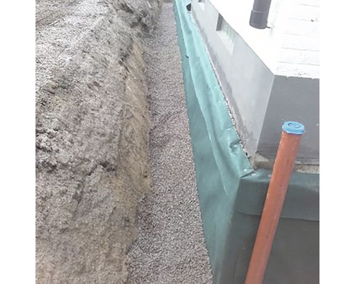 Schakt med dräneringsmaterial och skyddsfilm på en husvägg