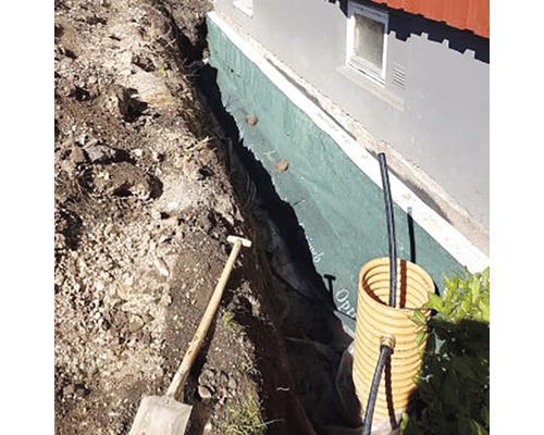 Byggnadsgrop med spade, dränering och tätad yttervägg