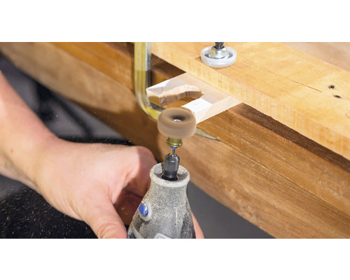 Dremel-verktyg som bearbetar en bit trä med en slipskiva.