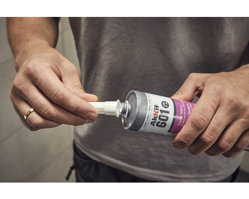 Användare fäster spetsen på en patron med sanitetsilikon