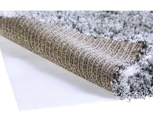 Detaljvy av en grå ryamatta, rullad för att visa texturen