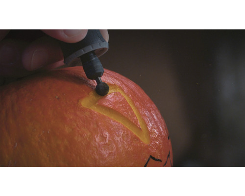 Person som skär pumpa med ett multifunktionsverktyg