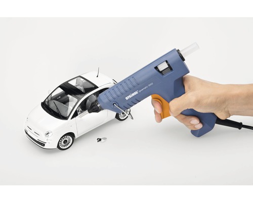 Smältlimspistol som limmar en leksaksbil