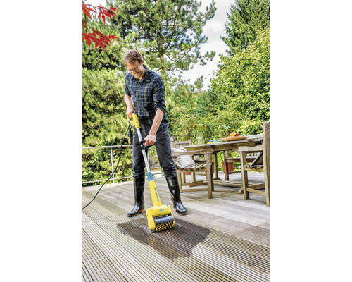 Man rengör en träterrass med en terrasstvätt.