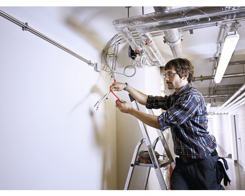 Elektriker arbetar med elektriska ledningar i en byggnad.