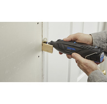 En person använder ett Dremel multiverktyg för att slipa trä.