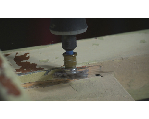 Ett multifunktionellt verktyg med borstfäste slipar trä.