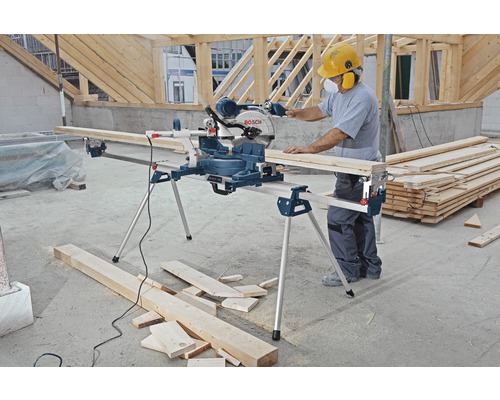 Man arbetar med en Bosch kap- och gersåg med arbetsbänk på en byggarbetsplats