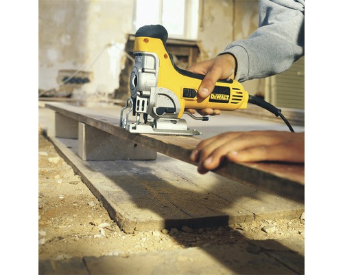 En sticksåg sågar en träplanka som vilar på block.