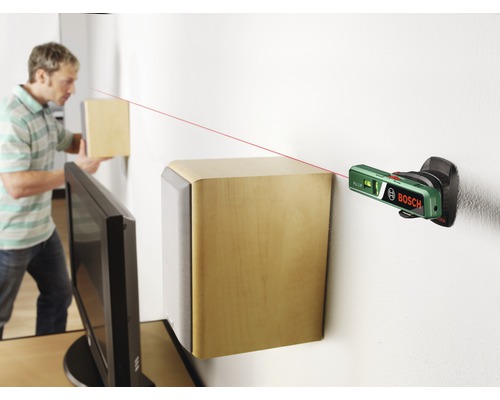 Scen med en person som riktar in högtalare på en vägg med ett laservattenpass