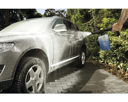 En bil rengörs med en högtryckstvätt och rengöringsmedel.