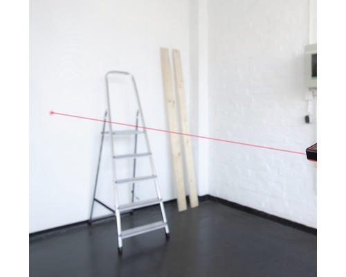 Rum med stege, träplankor och laseravståndsmätare med röd laserstråle