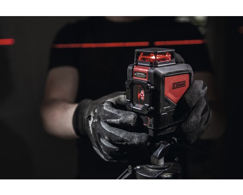 Person håller en JC Schwarz-korslaser på ett stativ