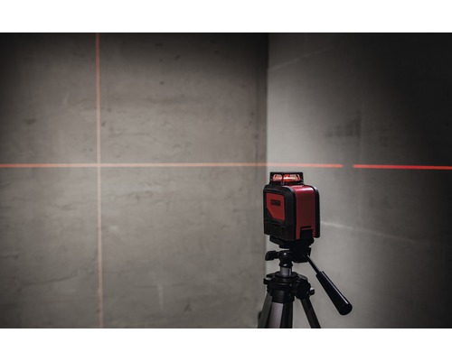 Röd krysslinjelaser på stativ projicerar linjer på en vägg